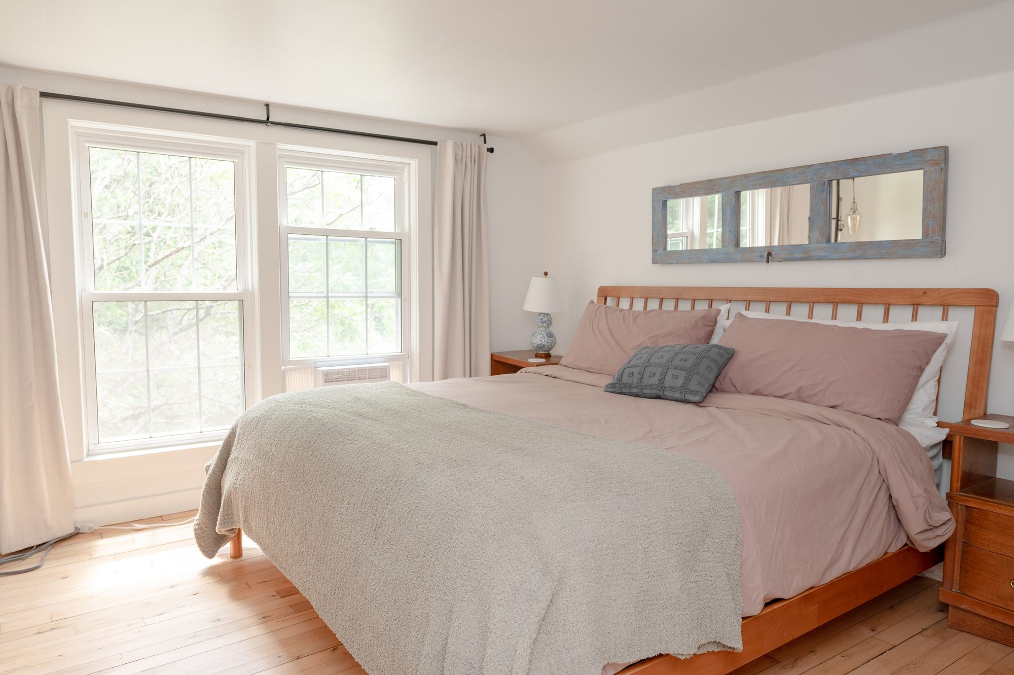 Primary king bedroom with windows and hardwood floors
