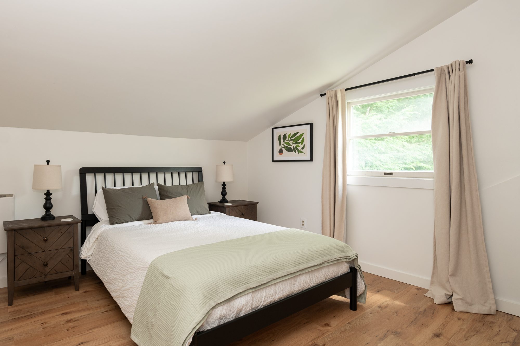 Queen bedroom with matching nightstands and natural light