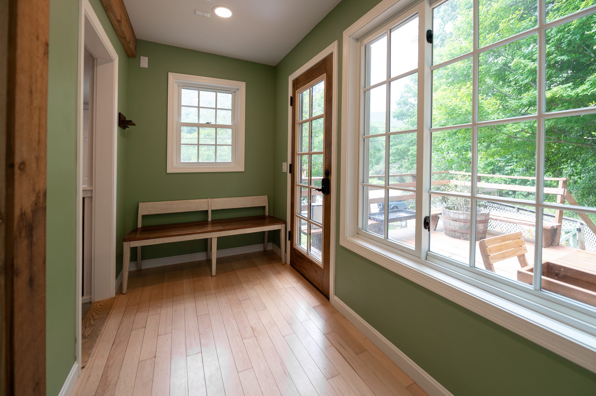 Mudroom entryway with bench and door to the deck